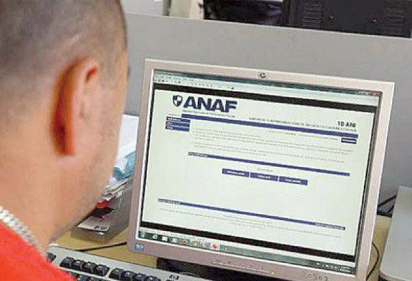 Un bărbat se uită pe site-ul ANAF să vadă ce datorii are
