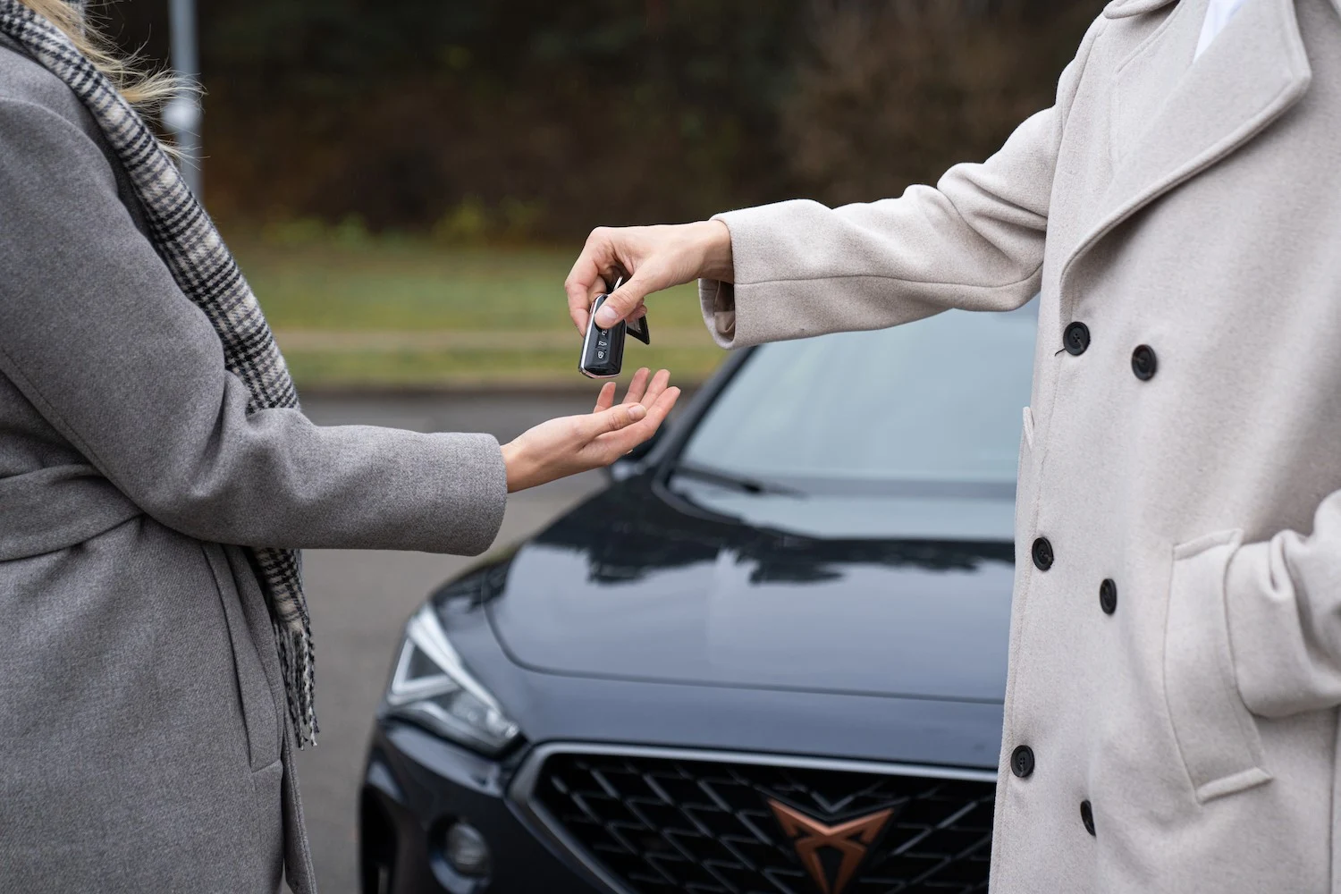 Vechiul proprietar predă cheile mașinii cumpărătorului
